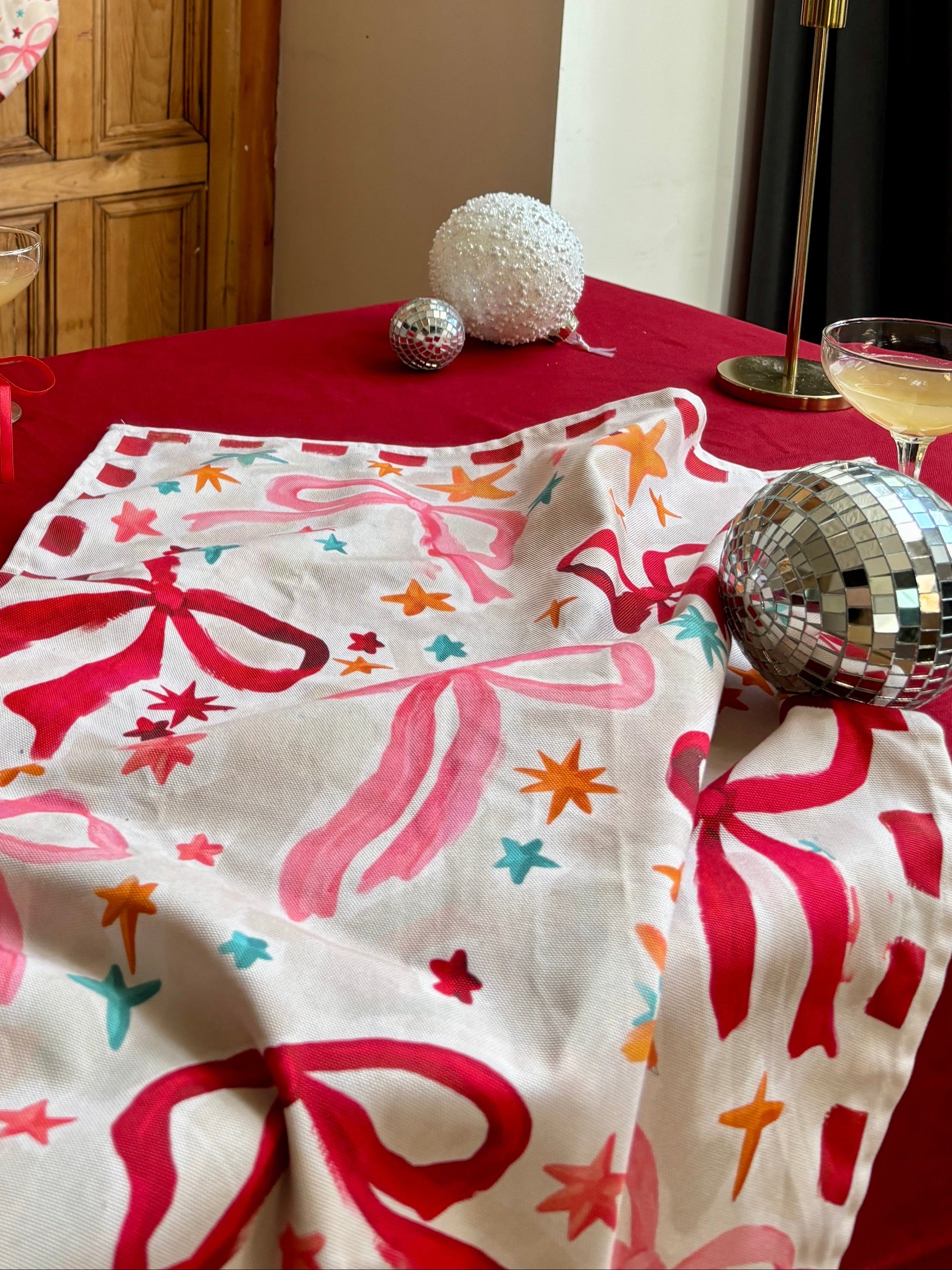 Decorative Christmas table setting with stockings, tablecloth, and candles.